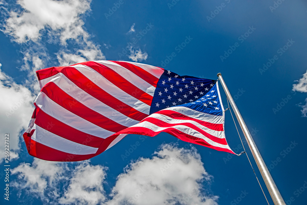 American Flag flying against a blue sky.