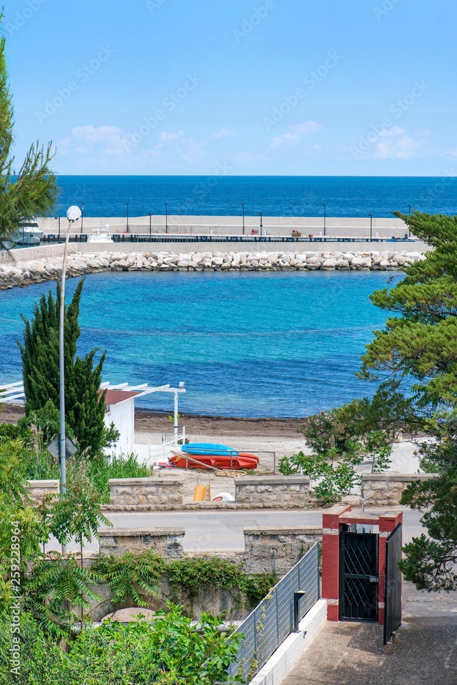 Fototapeta premium Beautiful drone view of harbor and beach side. Houses and buildings with solar panels built next to ocean or sea. Luxury lifestyle. Concept of travelling and summer holidays