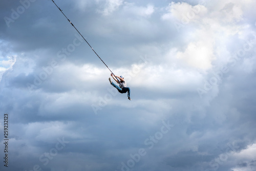 Rope jumping from high altitude bridge. Concept of overcoming fear, courage, active lifestyle, excitement, adventures and adrenaline. Summer sports festival outdoors. Young man having fun