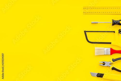 constructor desk with set of building implements and brushes yellow background top view mock up