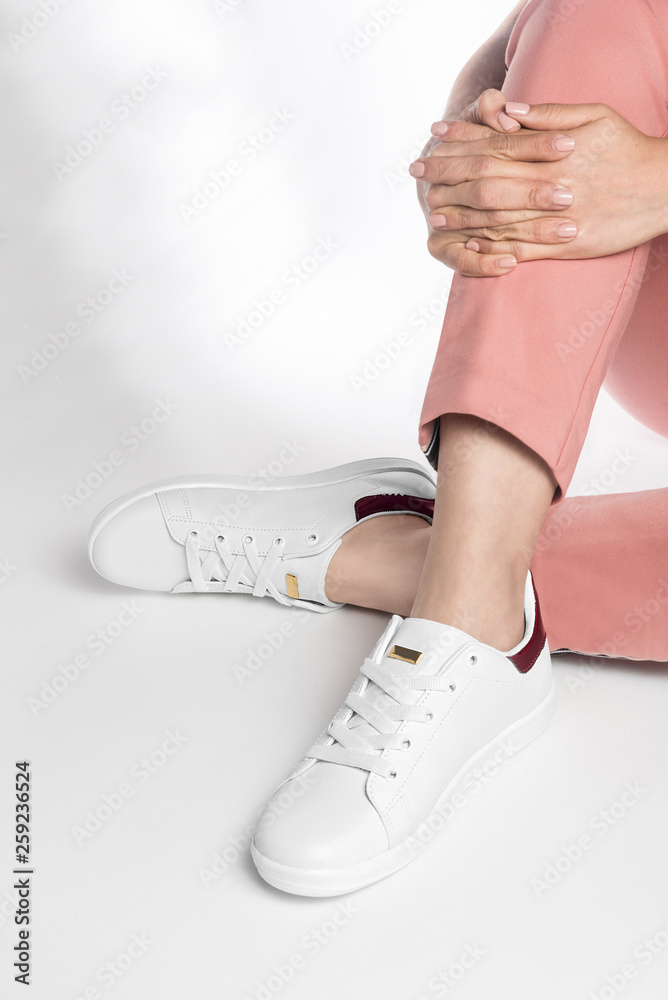 Mujer modelando zapatos tenis color blanco sobre fondoo blanco Stock Photo  | Adobe Stock