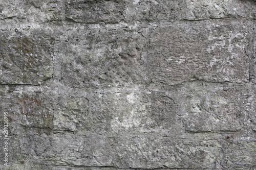 Hintergrundbild einer alten grauen Mauer aus Stein mit vielen Spalten, Rissen und Fugen 