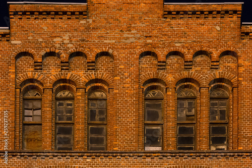 Facade of the old mill building at nighttime. Building of red brick