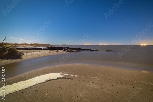 Small river flows into the sea. Nighttime