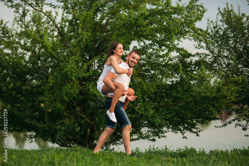 Two people have fun. Girl and boy run around near the lake