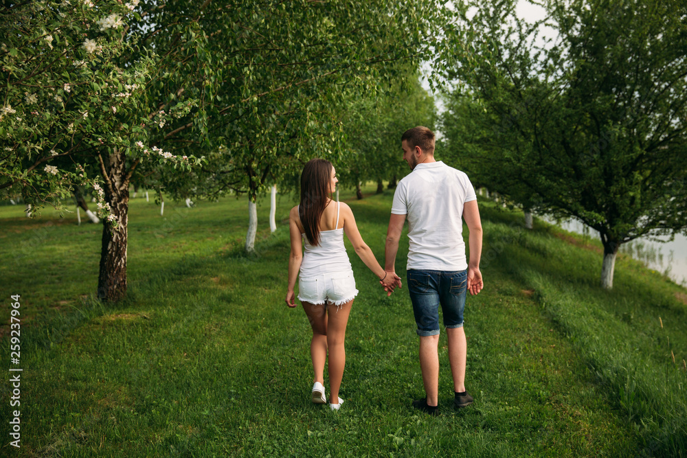 Man and girl walking around the park. Beautiful couple Man and girl walking around the park. Beautiful couple