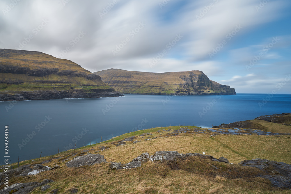 Epic landscape picture in Faroe islands shown open scandinavian countryside without trees, but with moorland, meadows and huge cliffs in wild north atlantic ocean. Epic landscape picture in Faroe islands shown open scandinavian countryside without trees, but with moorland, meadows and huge cliffs in wild north atlantic ocean.