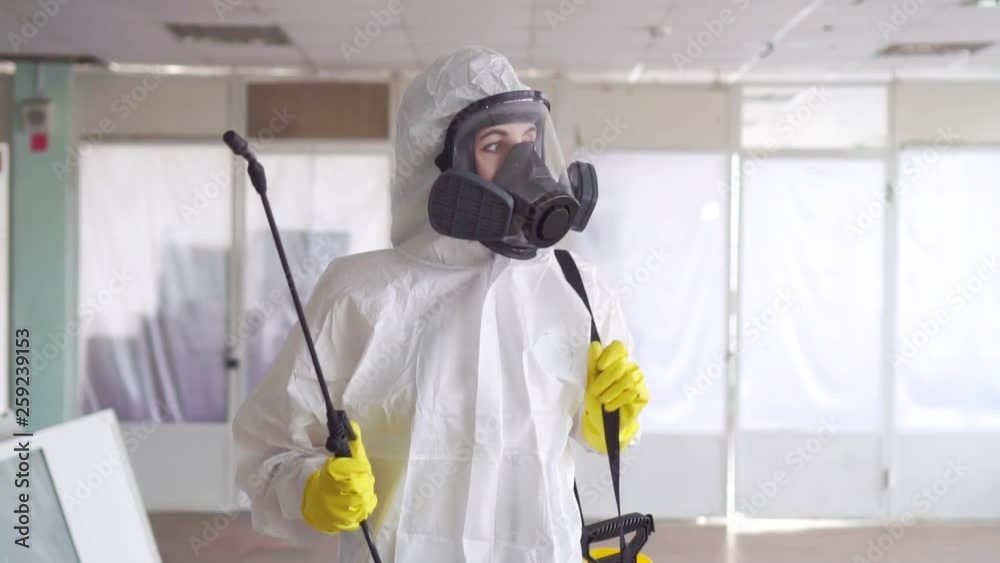 Portrait of the exterminator in overalls with a sprayer