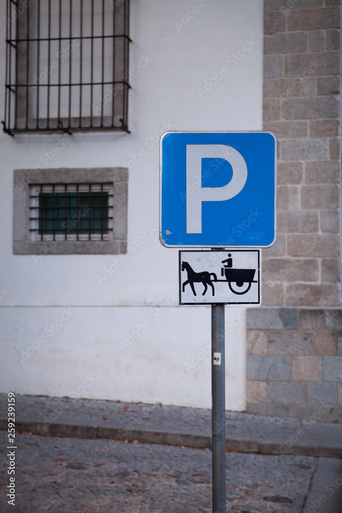 A parking sign for horses with a cart in the middle of an old city somewhere in Portugal A parking sign for horses with a cart in the middle of an old city somewhere in Portugal