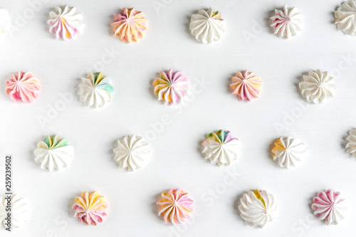 Multi-colored meringue on a white background. Sweets on the photo. Pattern with meringue on a white background. Sweet holidays