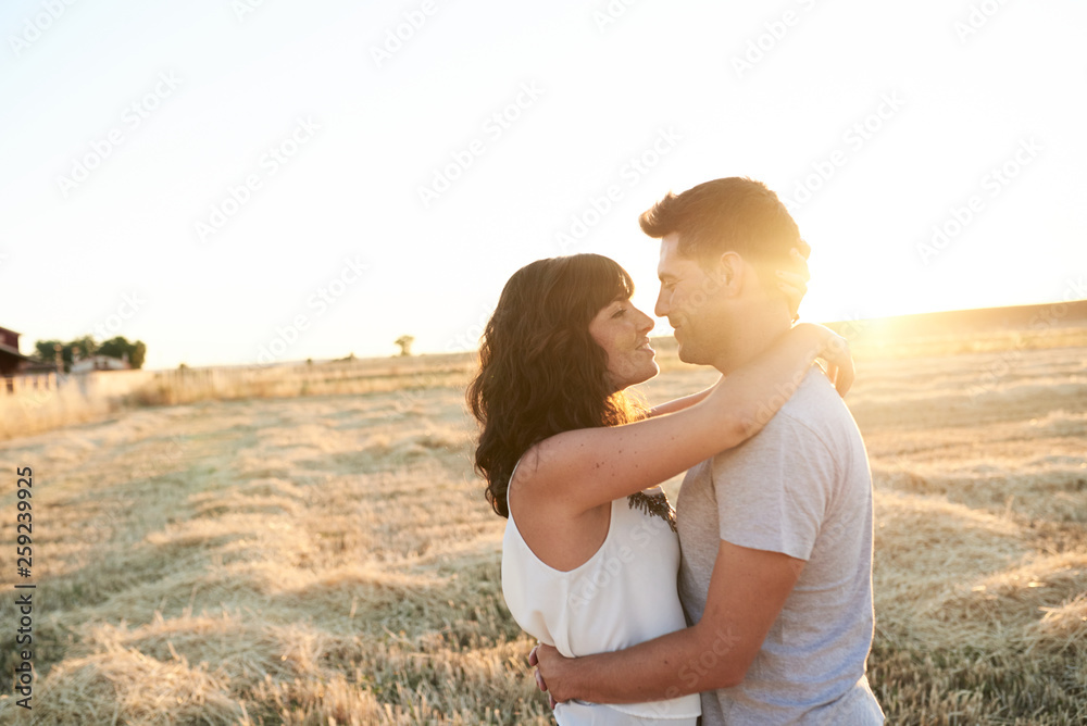 Smiling couple hugging face to face at sunset Smiling couple hugging face to face at sunset
