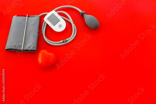 cardiologist work desk with pulsimeter on red background top view copyspace photo