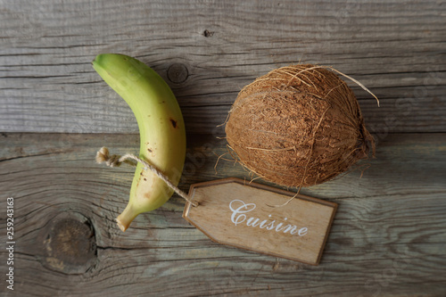 Banana carriyng a coconut on a decorative cuisine plate. Vegan food. Healthy eating concept. photo