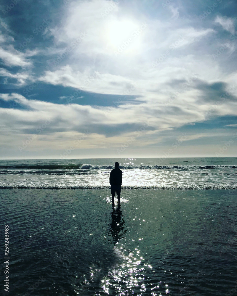 Silhouette of a man standing oceanside Silhouette of a man standing oceanside