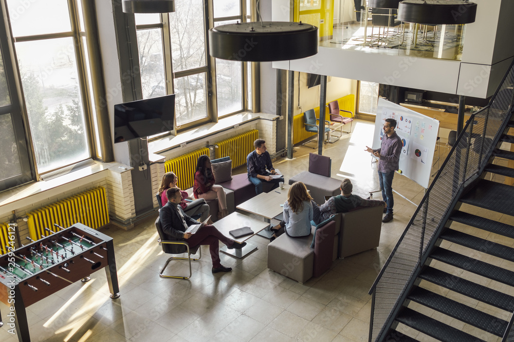 © Aleksandra Jankovic/Stocksy - Business People Watching Presentation At The Open Space Office