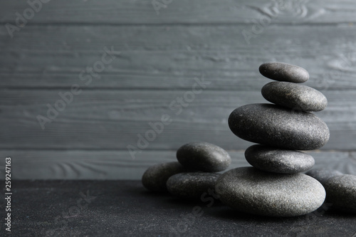 Stacked zen stones on table against wooden background. Space for text
