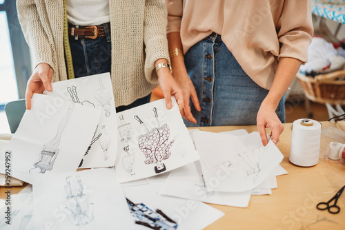 Two young female fashion designers working together at the design studio