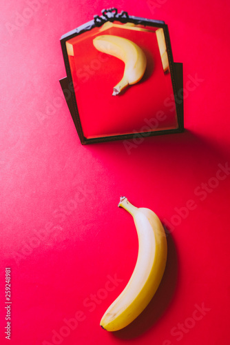 Lemon fruit reflecting as an orange on a mirror in a colored environemnt, conceptual image for the theme of changing , thinking difference, getting another pern photo