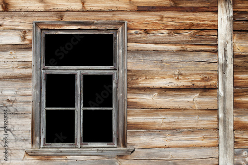Rustic window in wooden village cottage house. Grunge brown wood wall.