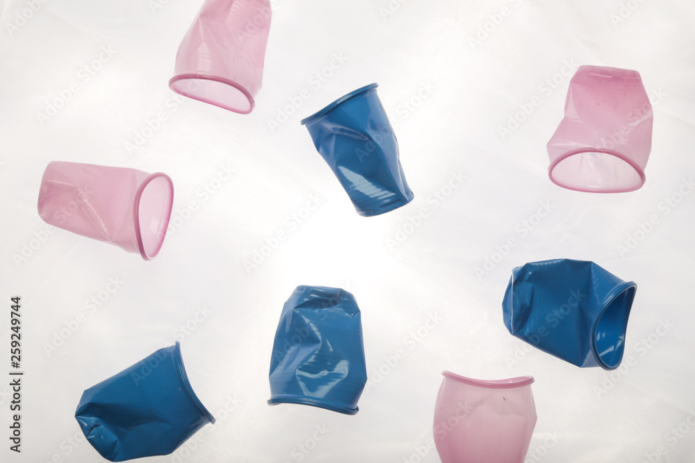 Crumpled empty single-use plastic cups, studio shot. Plastic pollution concept.