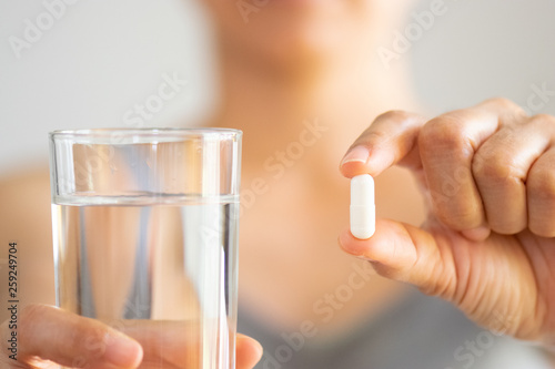 Close up of woman taking in pill  Medicine  health care and people concept.