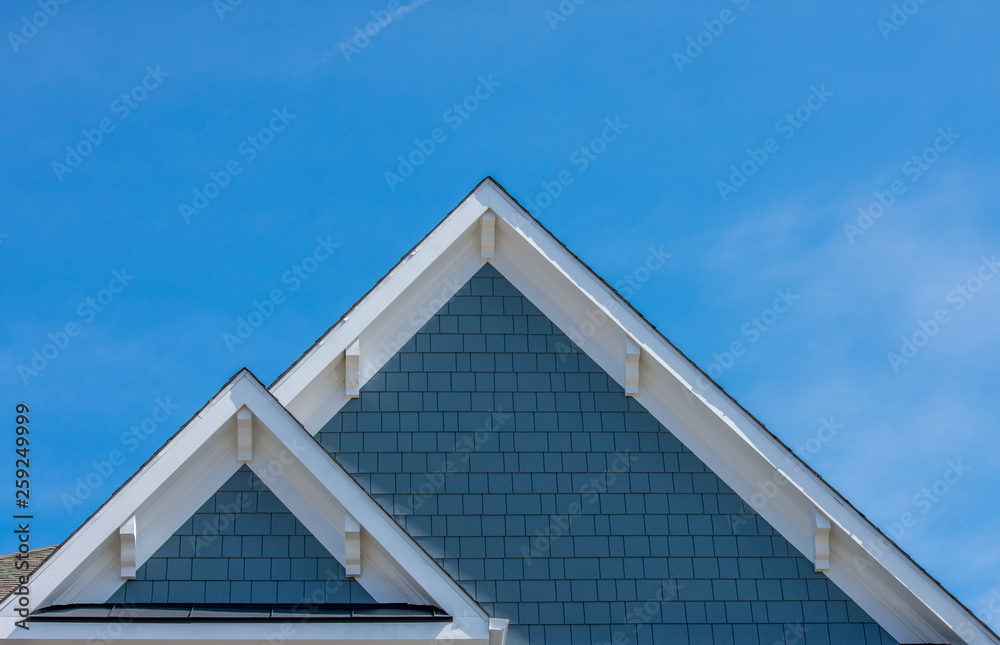 Plastic or wood white roof decoration gable, corbel, louver on a new construction luxury American single family home in the East Coast USA with blue sky background Plastic or wood white roof decoration gable, corbel, louver on a new construction luxury American single family home in the East Coast USA with blue sky background