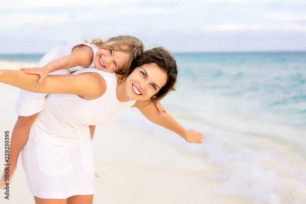 Portrait of happy mother and little daughter on sunny beach on Maldives at summer vacation Portrait of happy mother and little daughter on sunny beach on Maldives at summer vacation