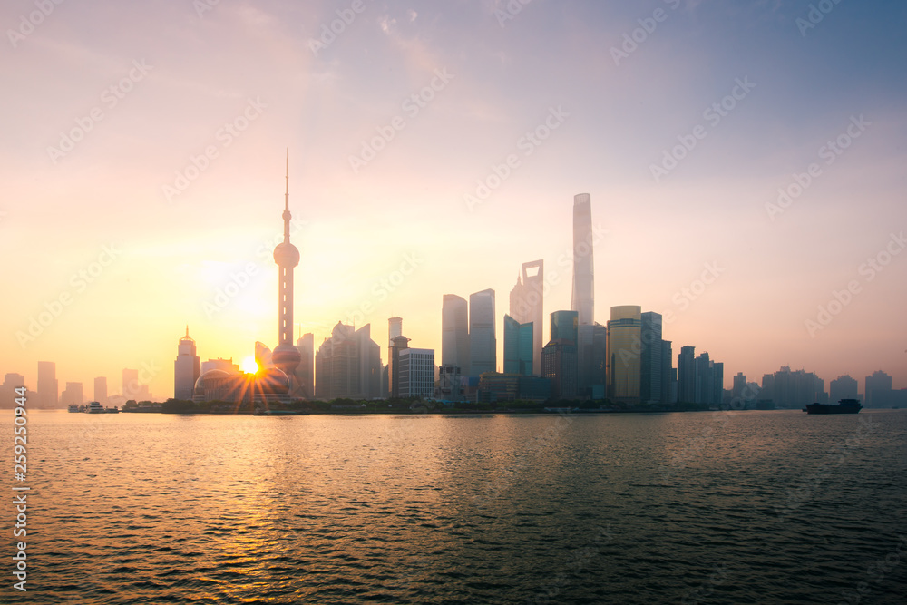 Shanghai, China city skyline during sunrise on the Huangpu River.