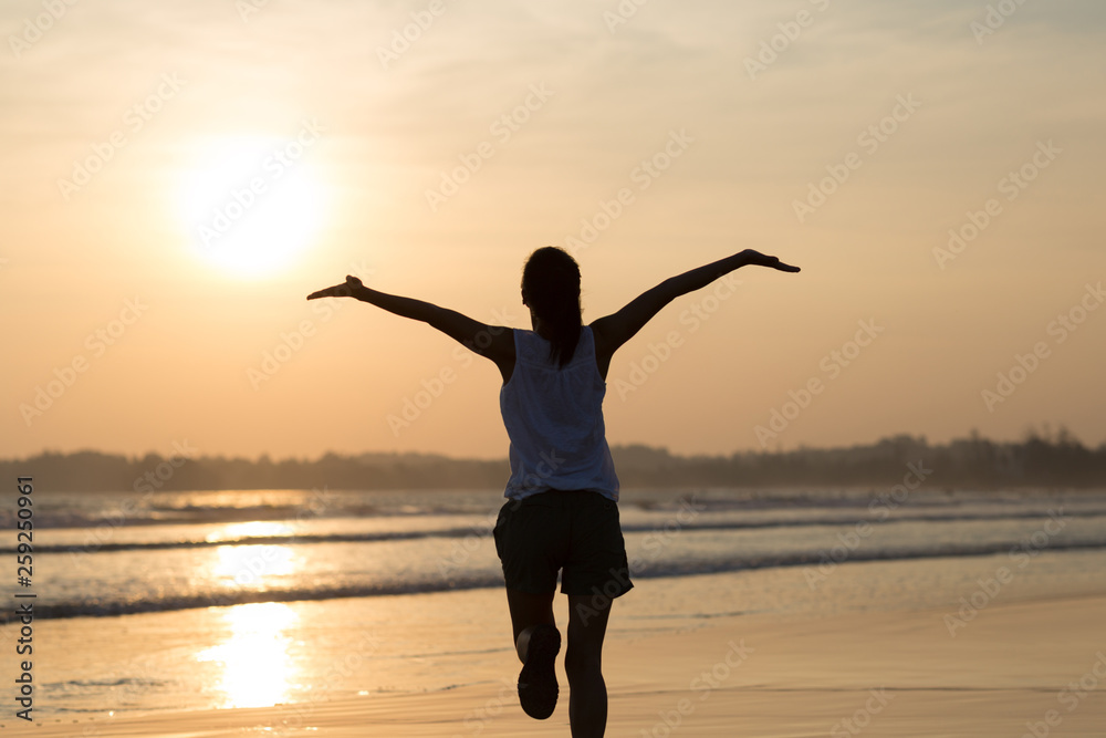 Happy Free Woman at Sunset on the Beach