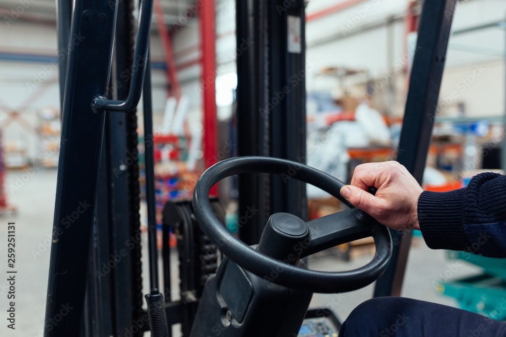 Man driving a forklift truck inside factory Man driving a forklift truck inside factory