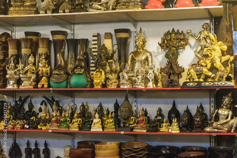 Various Thai Buddha statuettes and souvenirs for sale in local Bang Niang Night Market, Khao Lak, Thailand.