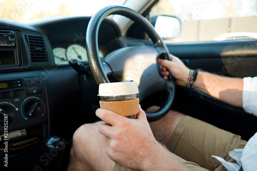 Coffee in drivers hand on a roadtrip photo