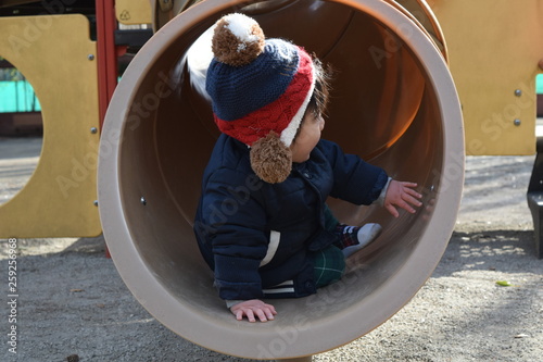 Infant playing with a tunnel type slide 1 year 7 months