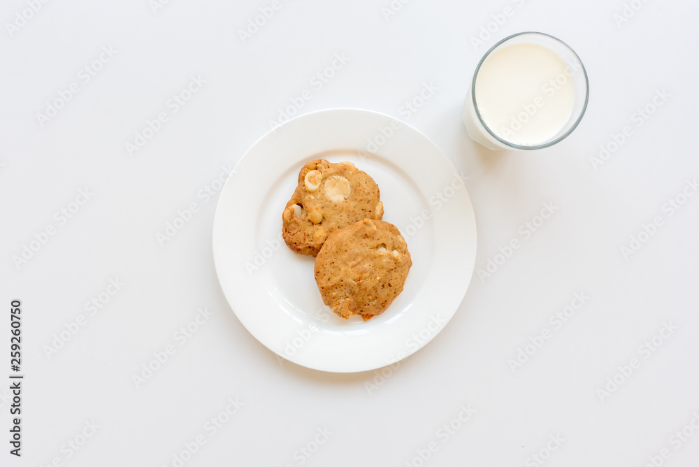 High angle view of homemade cookies on plate with glass of milk on white background High angle view of homemade cookies on plate with glass of milk on white background