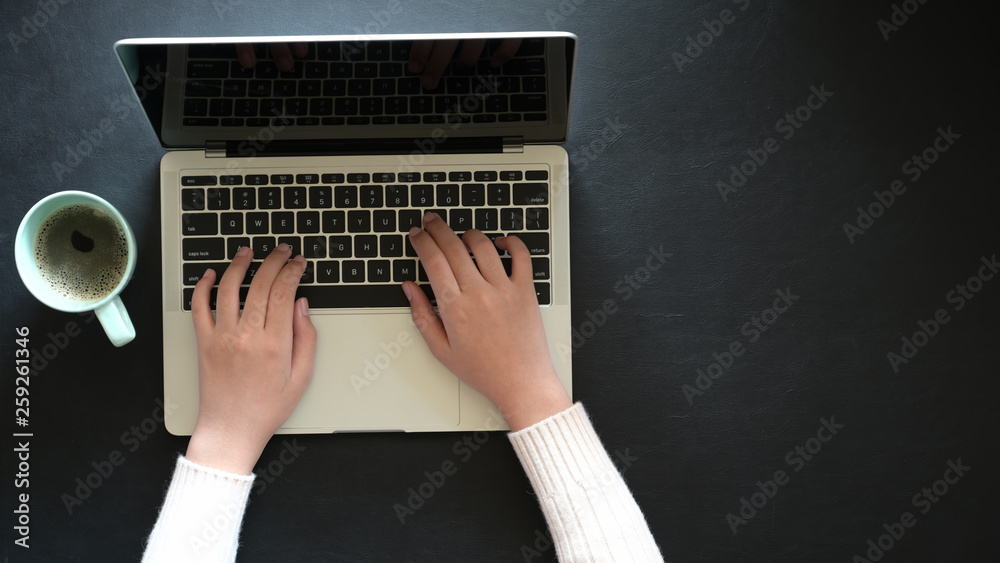 Famale working with laptop on dark leather office desktop and copy space Famale working with laptop on dark leather office desktop and copy space