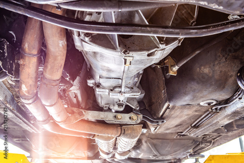 Closeup view of vehicle undercarriage on a lift in workshop during repairs