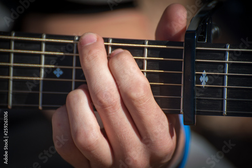Man fingering a chord on a guitar