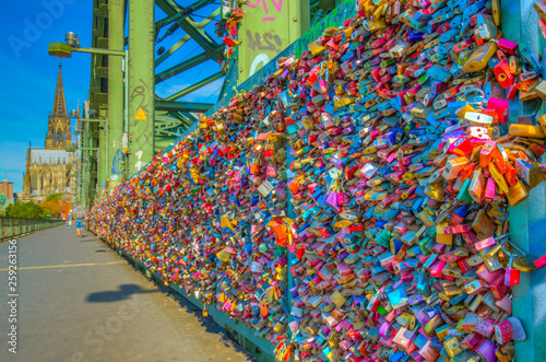 Detail of love locks on Hohenzollern bridge in Cologne with the cathedral at background, Germany photo