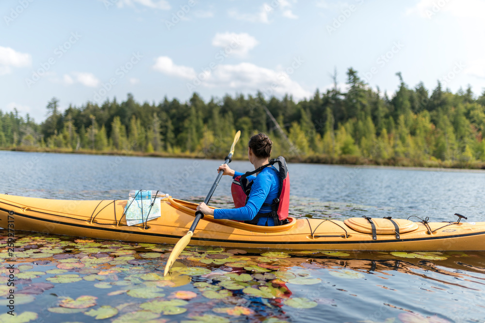 a woman looks to her right while kayaking