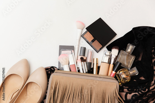 Makeup bag with cosmetic beauty products.  Beauty and Fashion concept. Shoes, makeup products and handbag on white background.