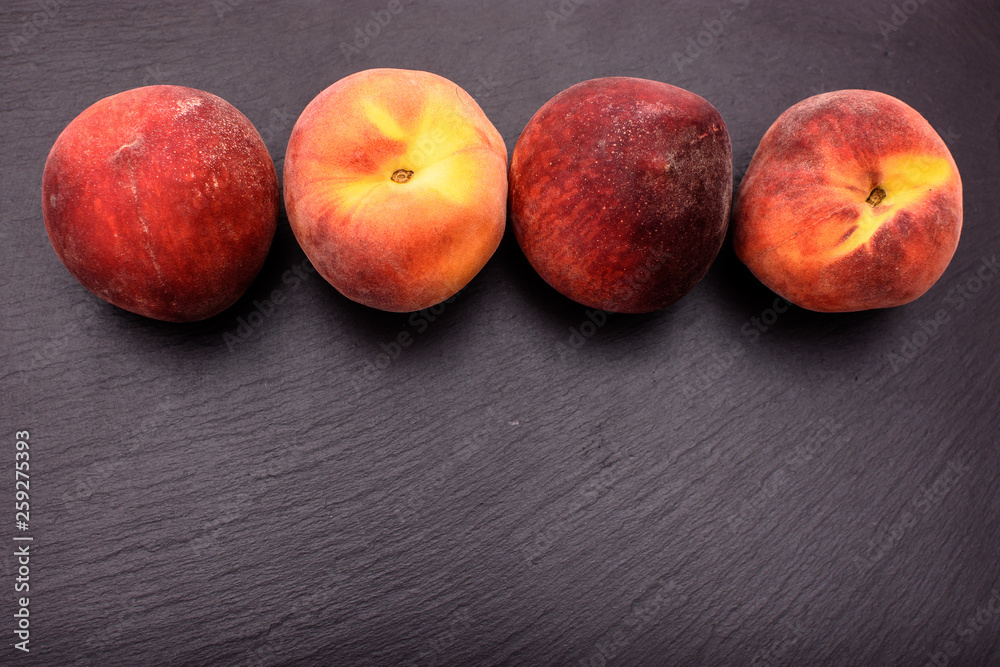 Peaches lie on a black stone slate, place for text Peaches lie on a black stone slate, place for text