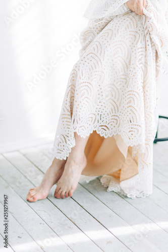 Beautiful bride sitting on a chair in the white Studio. Minimalistic wedding in European style. © pavelvozmischev