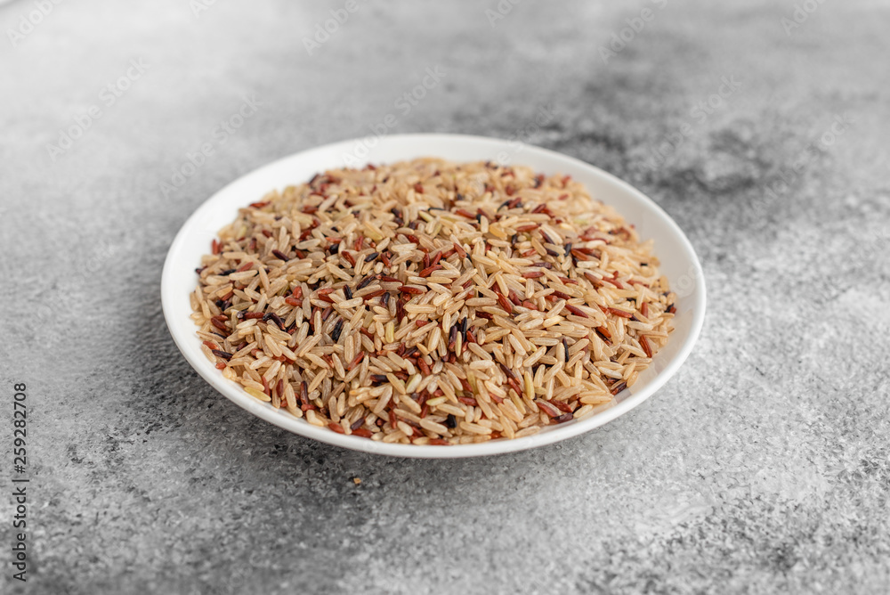 Rice in a white saucer on a gray concrete background Rice in a white saucer on a gray concrete background