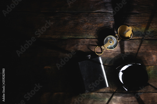 Travel or adventure flat lay background with a copy space. A flashlight, compass and water flask on a tourist table.