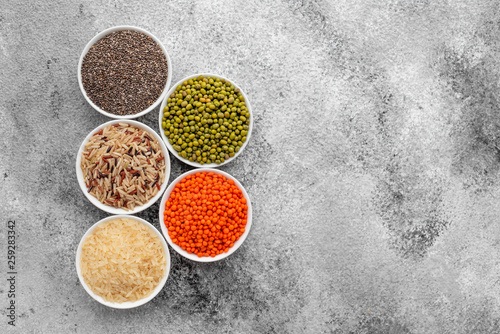 Variations of porridges and bean in white saucers on a gray concrete background