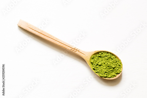 Matcha. Japanese powdered green tea in a spoon on a white background.