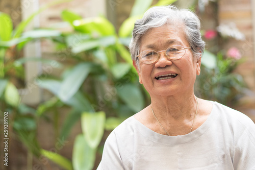 Happy senior society concept. Portrait of Asian female older ageing woman smiling with happiness in garden at home, nursing home, or wellbeing county