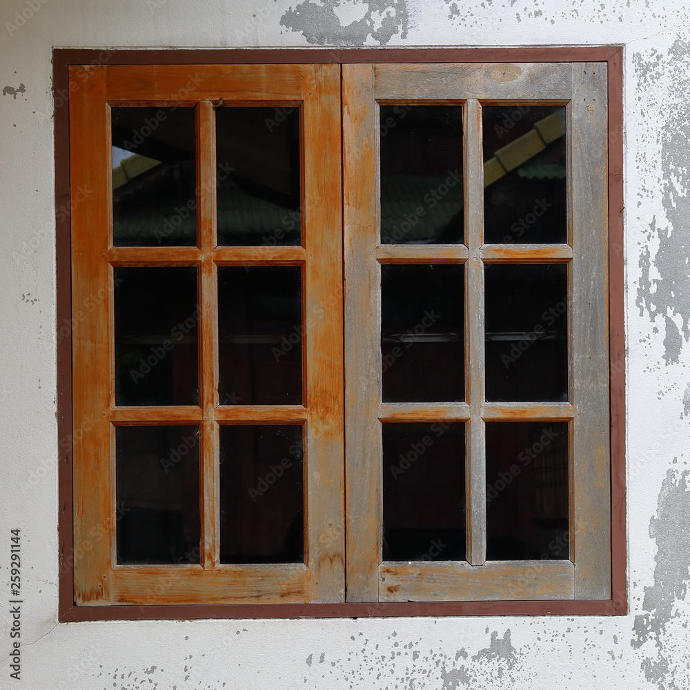 old glass window with wooden frame on weathered wall old glass window with wooden frame on weathered wall