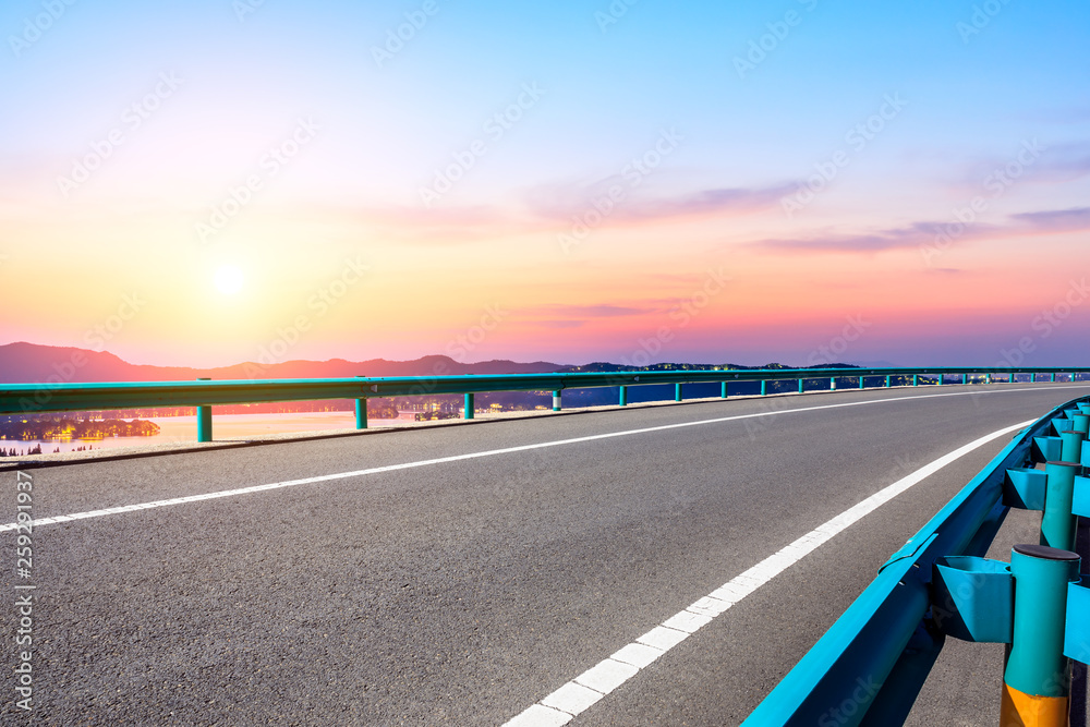 Fototapeta premium Asphalt road and beautiful mountain nature landscape at sunset