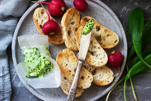 Butter with wild garlic, slices of bread and radish, ingredients for making a sandwich.